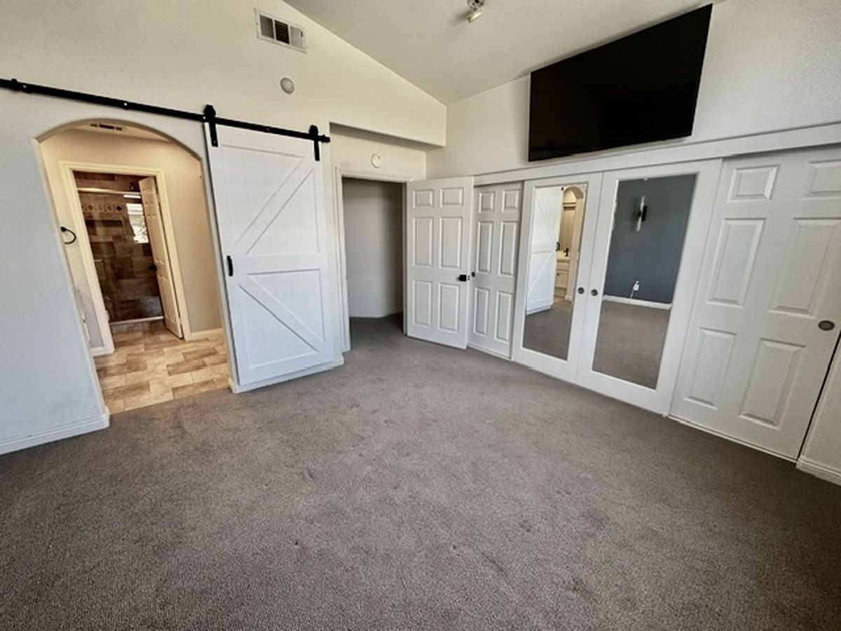 Bedroom with barn door and mirrored closet