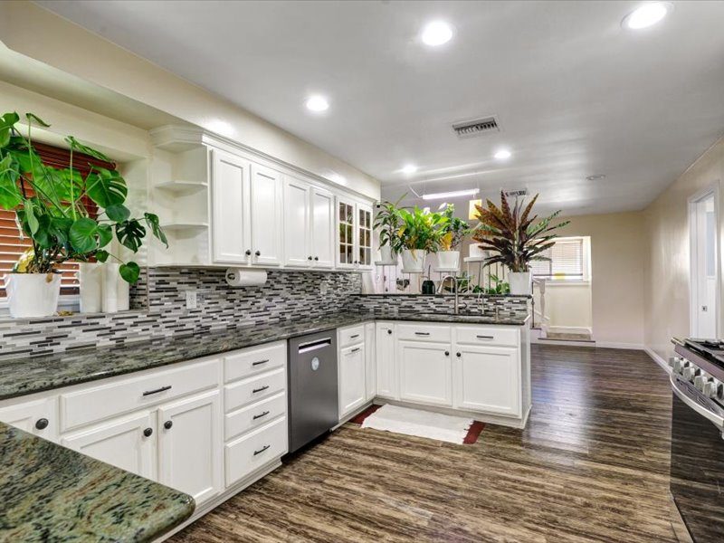 Kitchen with granite counters and white cabinetry